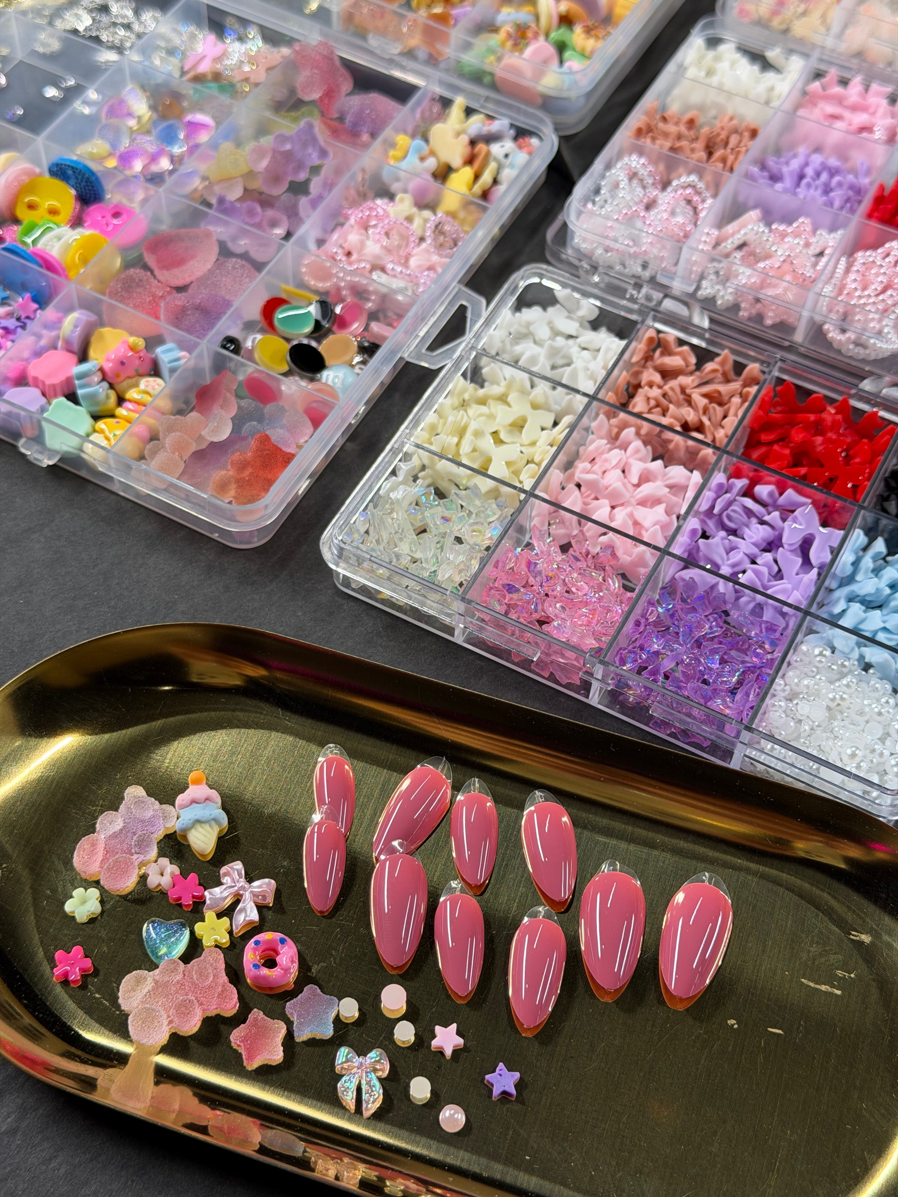 Press-on nails roses sur un plateau doré